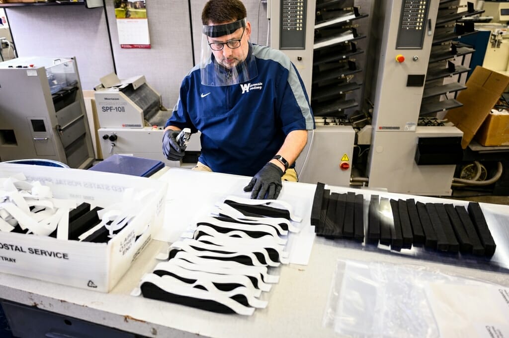 Staff member Ken Parman fabricates and packages custom-made medical face shields at the Division of Information Technology's Digital Publishing and Printing Services facility. Photo by Jeff Miller