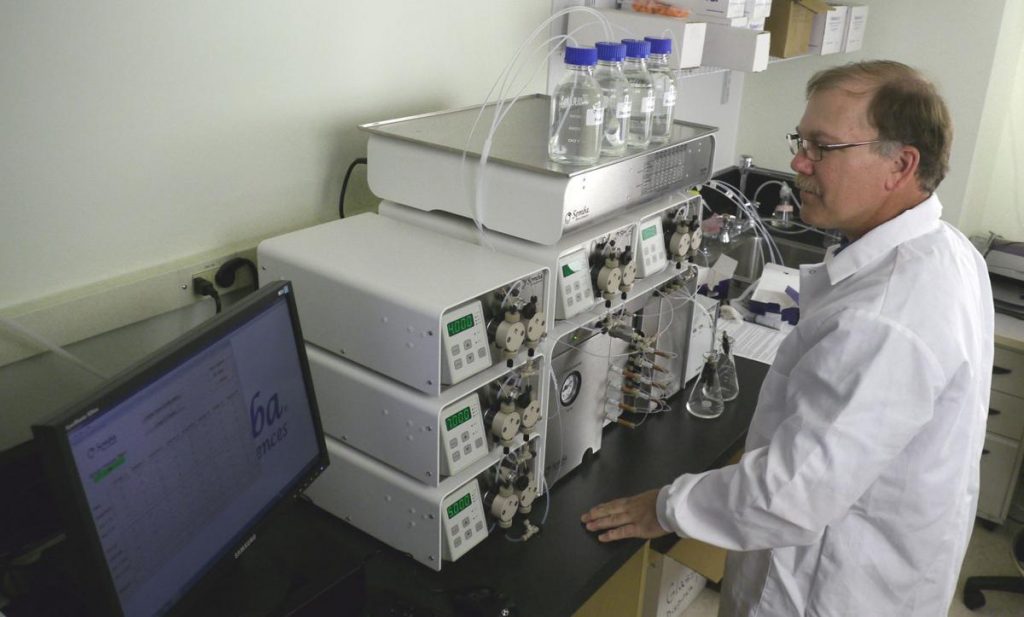 Semba Biosciences research and development director Tony Grabski looks over the company's Octave Chromatography System in preparation for a possible run of the equipment. Octave purifies biological products that could someday become new drugs. SEMBA BIOSCIENCES