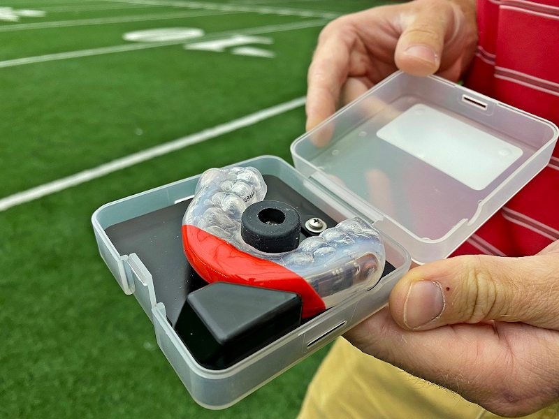 Daniel Cobian holds a specialized mouthguard that will be used by football players involved in the study. The sensors in the mouthguard will collect data on head impacts.