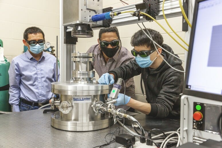 UW–Madison mechanical engineering professor Lianyi Chen, left, and doctoral students Luis Escano and Minglei Qu, right, work in Chen’s lab, where they developed a technique to limit defects in 3D printing with metals. UW–MADISON PHOTO BY RENEE MEILLER.