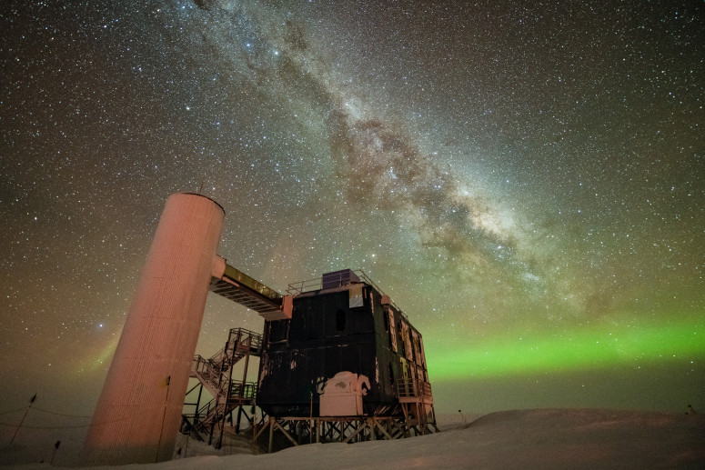 A view of the IceCube Lab with a starry night sky showing the Milky Way and green auroras. Photo By: Yuya Makino, IceCube/NSF